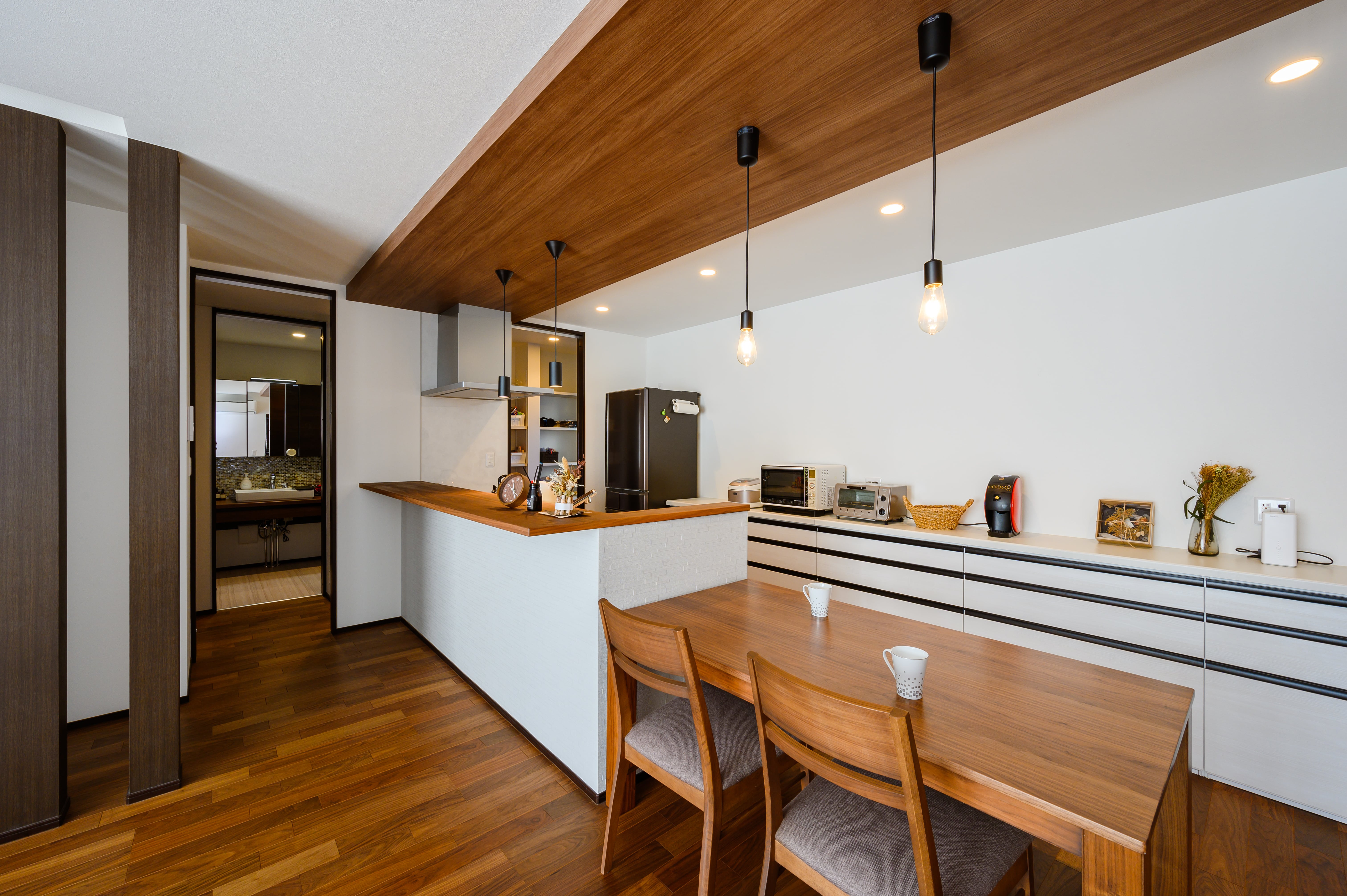 キッチンのカウンターに高級感のあるウォルナットの突板仕上げは上野さんの提案。