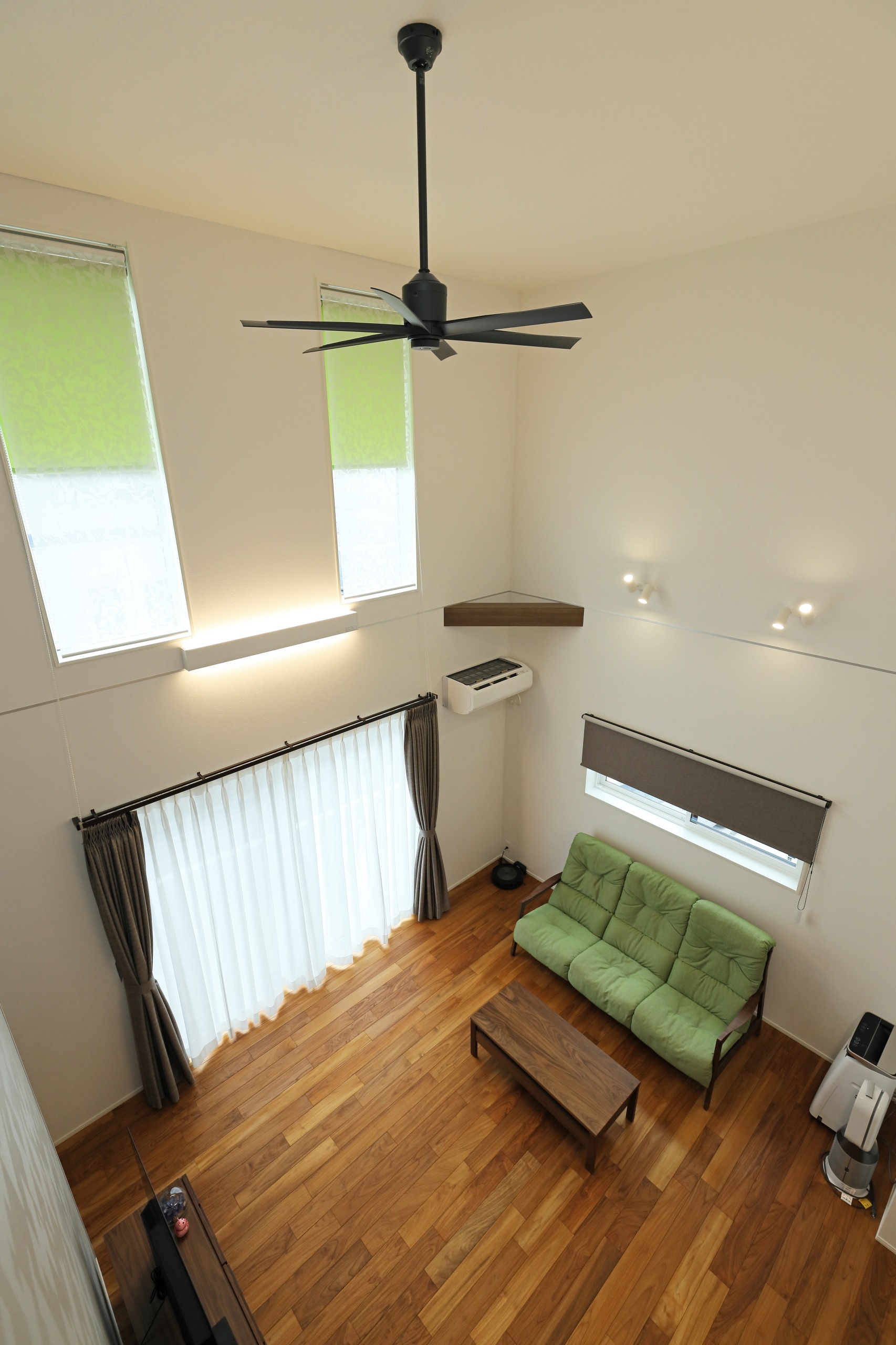 小窓のロールスクリーンとカーテン、ソファをモスグリーンで統一し、居心地よい落ち着きのある空間に。