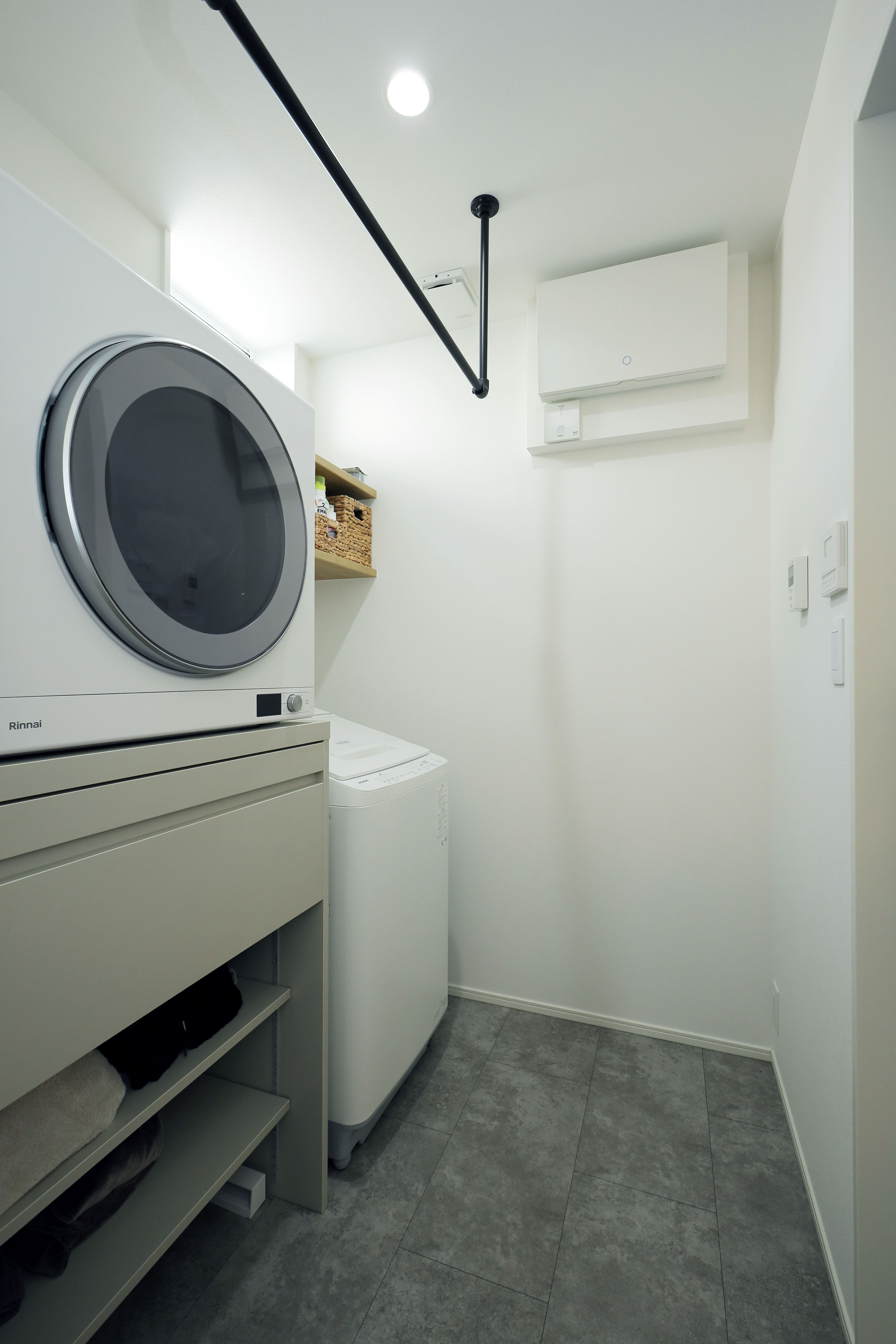 脱衣所に洗濯・乾燥機を置き、収納できる天板を取り付けて脱衣所内で洗濯物を畳めるようにした。