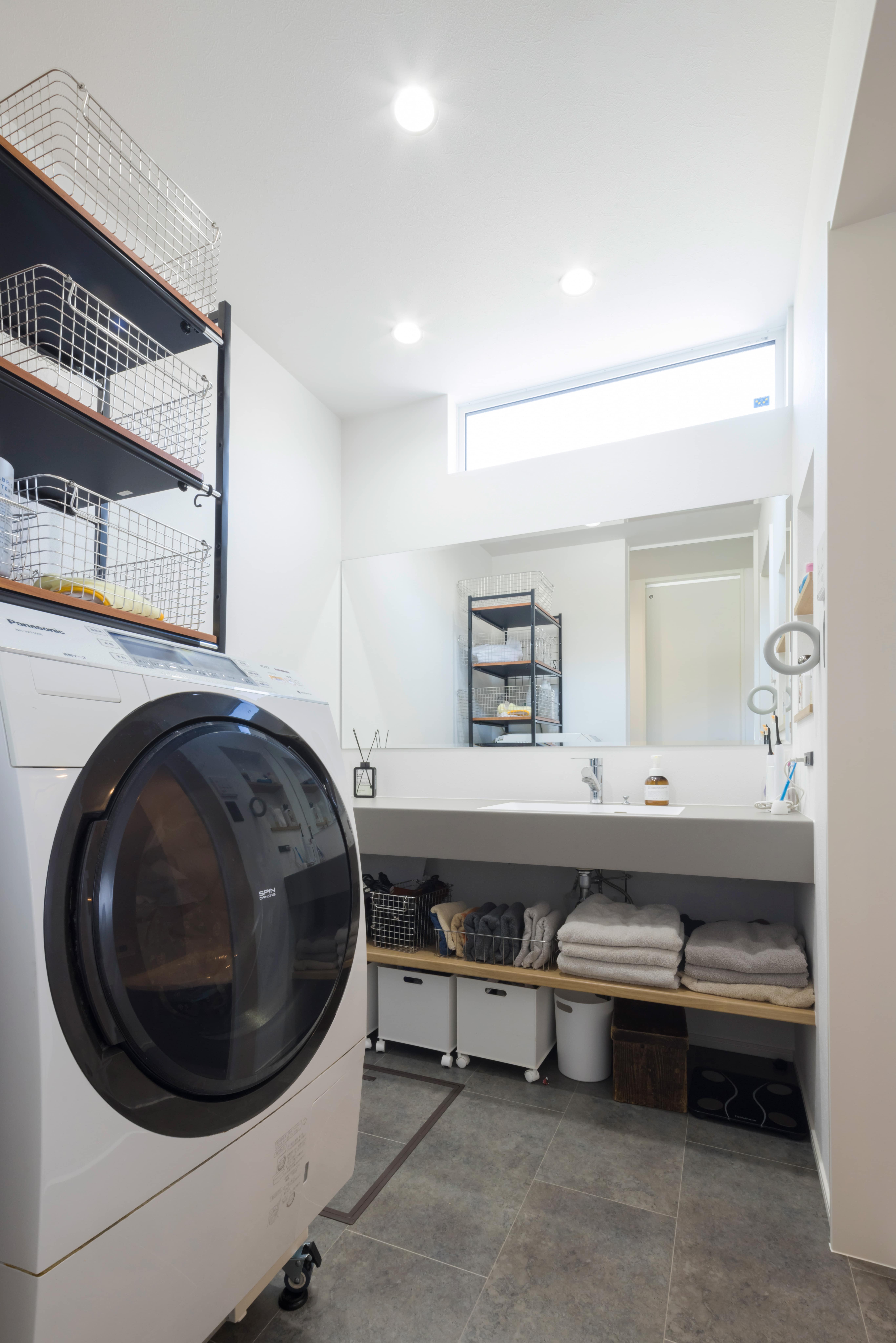 洗面スペースの下段には日常使いのタオルなどを収納するスペースを設け、すぐ隣にはウォークインクローゼットを。行き来を最小限にする工夫を随所に感じられる。