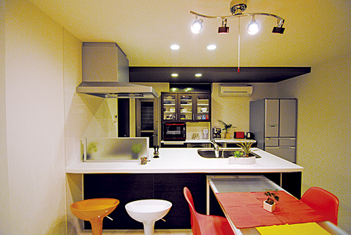 オープンスタイルの洒落たキッチンに、ビビッドなカラーの椅子が映える