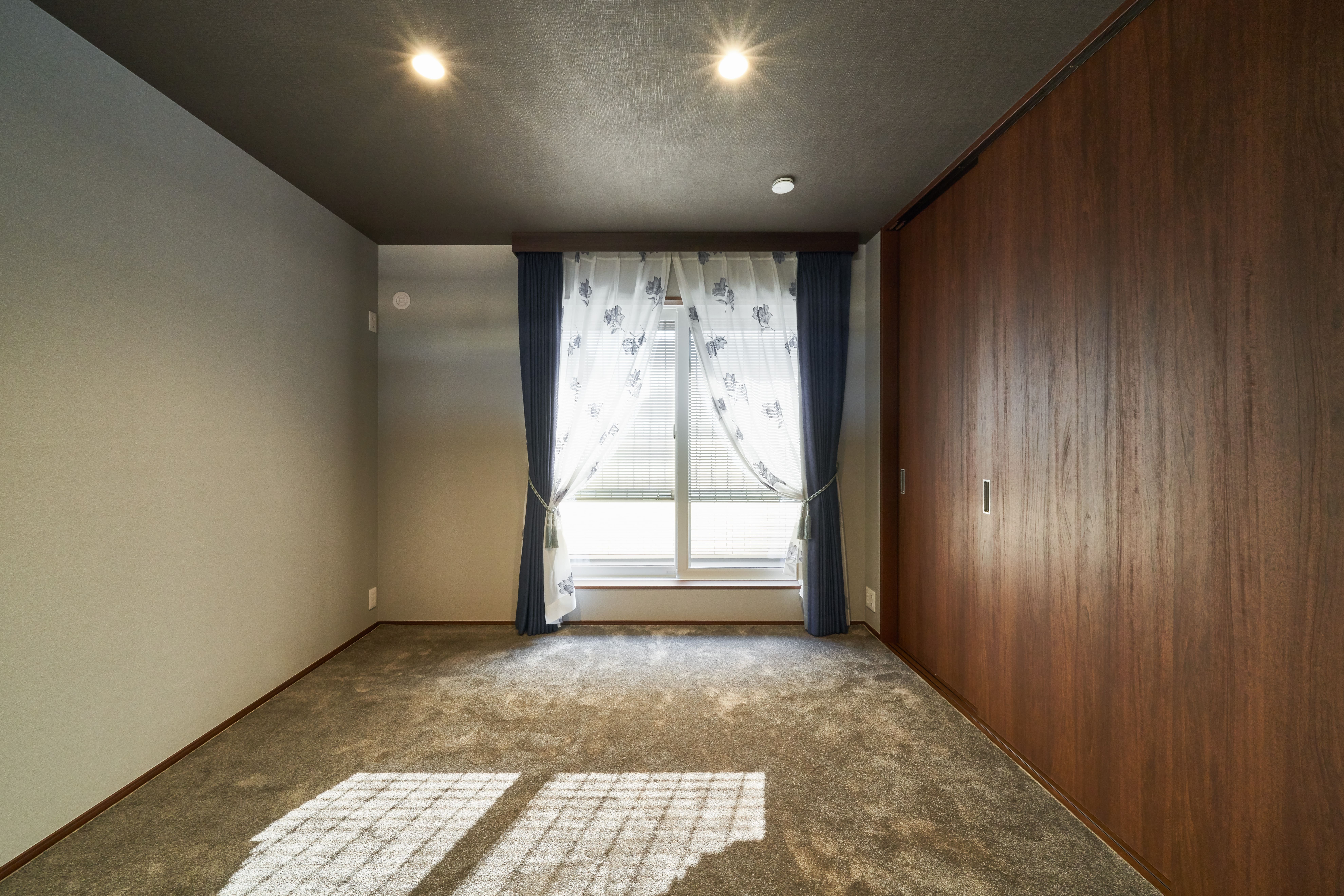 床・天井・壁をダークトーンでまとめ、高級感・重厚感のあるホテルライクな寝室に。電動窓シャッターで明るさ調節も可能。